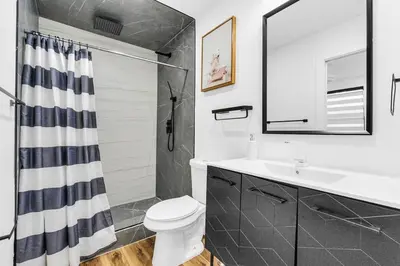 a bathroom with a toilet and a sink and a shower at Modern Home with large private yard - Next to downtown & beach & airport - Pet friendly in Fort Lauderdale