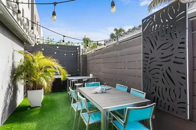 a patio with a table and chairs and a fence at Stunning, Modern and Quiet Beach House in Hollywood