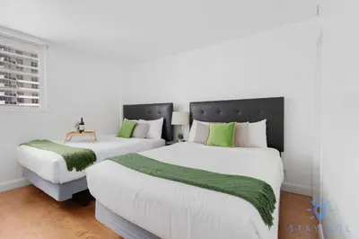 two beds in a room with white and green at Tides Great condo on the beach Big promotions in Hollywood