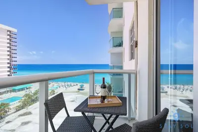 a table with a bottle of wine on a balcony with the ocean at Tides Great condo on the beach Big promotions in Hollywood