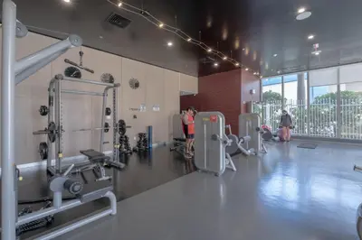 a gym with machines and people in a room at Miami Beach Apartment with piscina and gym in Hallandale Beach