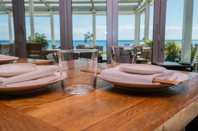 a wooden table with plates and glasses on it at Miami Beach 1B1B Apmt Amazing Intercoastal View in Hallandale Beach