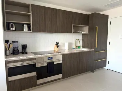 a kitchen with dark wood cabinets and a sink at Sky-High Views Pool – Steps from Miami Arena in Miami