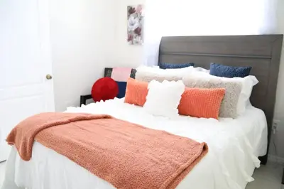 a bedroom with a bed with an orange blanket on it at Luxury DreamStay Miami 3BED 2BATH King Suite in Burrs Strip