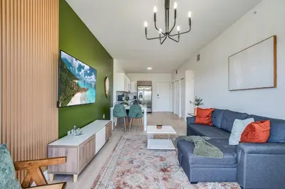 a living room with a blue couch and a green wall at New 2br 2bath 5 mins from beach 15 mins airport in Hallandale Beach