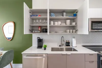 a kitchen with white cabinets and a sink at New 2br 2bath 5 mins from beach 15 mins airport in Hallandale Beach