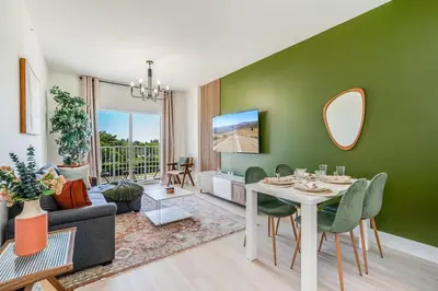 a living room with a table and a green wall at New 2br 2bath 5 mins from beach 15 mins airport in Hallandale Beach