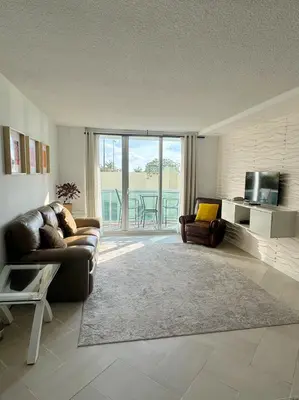 a living room with a couch and a television at Beachfront one bedroom in the Tides in Hollywood in Hollywood