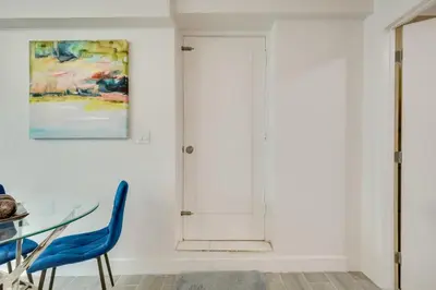 a dining room with a glass table and blue chairs at 2 Mi to Hard Rock Stadium Studio in Miami Gardens in Miami