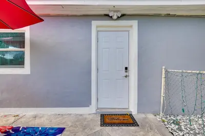 a white door of a house with a fence at 2 Mi to Hard Rock Stadium Studio in Miami Gardens in Miami