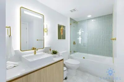 a bathroom with a sink and a toilet and a mirror at Modern Stylish 1BR Apartment with Pool in Miami