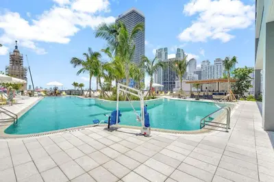 a large swimming pool with palm trees and buildings at Modern Stylish 1BR Apartment with Pool in Miami