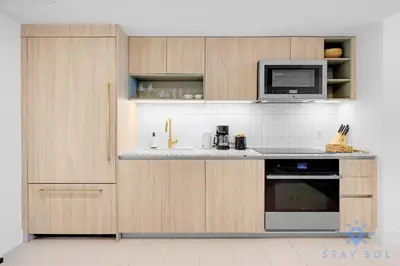 a kitchen with wooden cabinets and a microwave at Modern Stylish 1BR Apartment with Pool in Miami