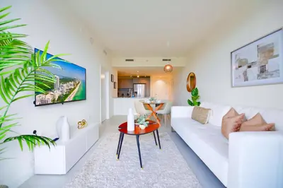 a living room with a white couch and a table at Beautiful and Stylish Condo Close The Doral Park in Miami