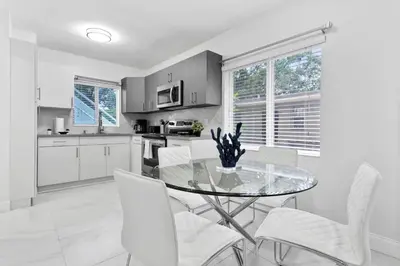a kitchen with a glass table and white chairs at Celeste House Enjoy Caribbean 2BR APT in Miami