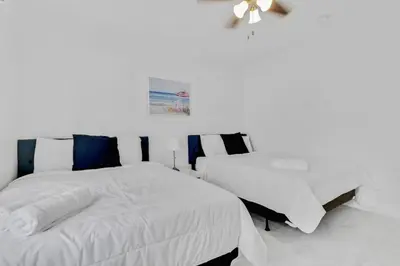 a white bedroom with two beds and a ceiling at Celeste House Enjoy Caribbean 2BR APT in Miami