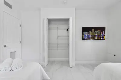 a white room with two beds and a painting on the wall at Celeste House Enjoy Caribbean 2BR APT in Miami