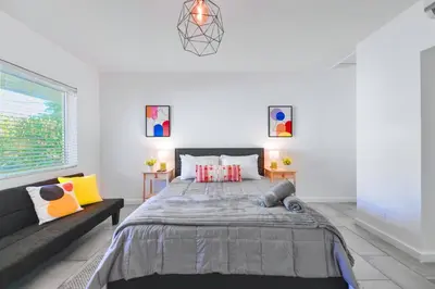 a bedroom with a large bed and a couch at Beach and Art Close to This Lovely Studio in Miami