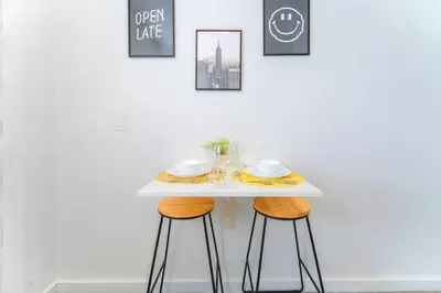a table with two chairs and a white table with plates and cups at Beach and Art Close to This Lovely Studio in Miami