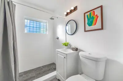 a white bathroom with a toilet and a shower at Beach and Art Close to This Lovely Studio in Miami