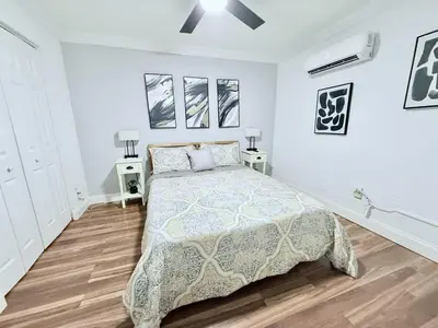 a white bedroom with a bed and two night stands at Retreat in Style Private Peaceful Miami Bungalow in Olympia Heights