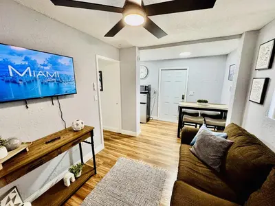 a living room with a couch and a table at Retreat in Style Private Peaceful Miami Bungalow in Olympia Heights