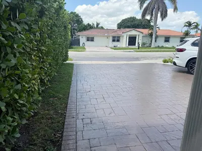 a driveway in front of a house with a hedge at Retreat in Style Private Peaceful Miami Bungalow in Olympia Heights