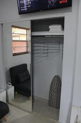 a room with a closet with a couch and a chair at Coral Gables Guest Studio in Miami