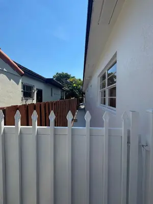a white fence in front of a house at Coral Gables Guest Studio in Miami