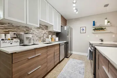 a kitchen with wooden cabinets and white appliances at The Jungalo Pool & Billards in Fort Lauderdale