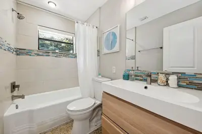 a bathroom with a white tub and a toilet and a sink at The Jungalo Pool & Billards in Fort Lauderdale
