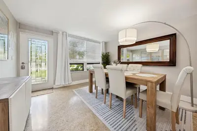 a dining room with a table and chairs and a mirror at The Jungalo Pool & Billards in Fort Lauderdale