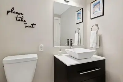 a white bathroom with a sink and a mirror at The Jungalo Pool & Billards in Fort Lauderdale