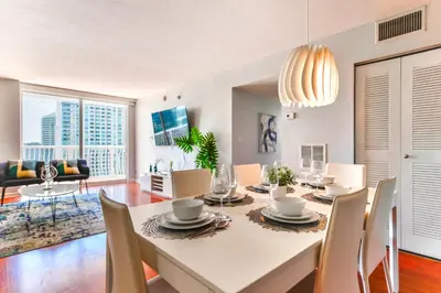 a dining room with a white table and chairs at Upscale Condo in Brickell in Miami