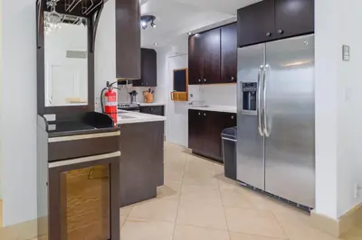 a kitchen with a stainless steel refrigerator and wooden cabinets at Hollywood Beachfront Retreat in Hollywood