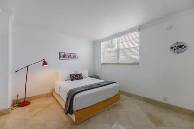 a white bedroom with a bed and a window at Hollywood Beachfront Retreat in Hollywood