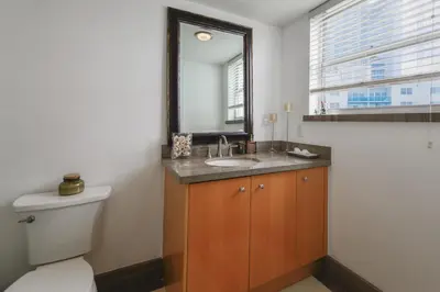 a bathroom with a sink and a toilet and a mirror at Hollywood Beachfront Retreat in Hollywood