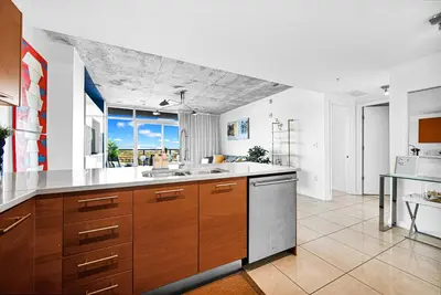 a large kitchen with wooden cabinets and a large window at Exclusive unit in Miami Sunshine in Miami