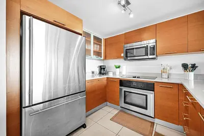 a kitchen with wooden cabinets and a stainless steel refrigerator at Exclusive unit in Miami Sunshine in Miami