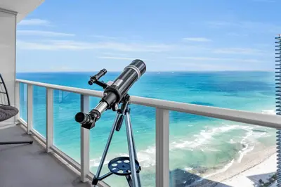 a telescope on a balcony looking at the ocean at Ventur Luxe Condo - Oceanview - Gym, Beach Access in Hollywood