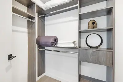 a walk in closet with wooden shelves and a mirror at Designer Studio Downtown Miami with Rooftop Pool and Gym in Miami