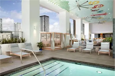 a rooftop patio with a pool and chairs and a building at Designer Studio Downtown Miami with Rooftop Pool and Gym in Miami