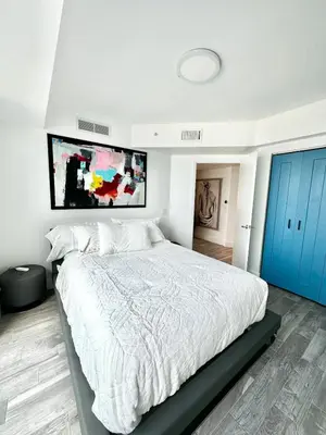 a bedroom with a large white bed and blue doors at LOFT Brickell River 10 min To South Beach in Miami