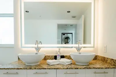 a bathroom with two sinks and a mirror at LOFT Brickell River 10 min To South Beach in Miami