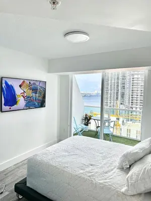 a bedroom with a bed and a view of the ocean at LOFT Brickell River 10 min To South Beach in Miami