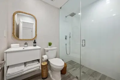 a bathroom with a toilet and a shower with a mirror at Lux Designer Apt 2BR and 2BA in the Heart of MIA Beach in Miami Beach