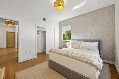 a bedroom with a large bed and a wall at Lux Designer Apt 2BR and 2BA in the Heart of MIA Beach in Miami Beach