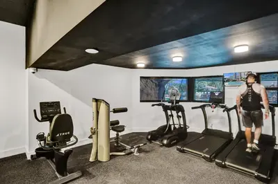 a man standing in a gym with two tread machines at Luxury Condo with Resort Amenities Pools Gym and Sauna 804 in Miami Beach