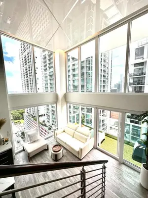 a living room with large windows and a couch at LOFT Brickell River 10 min To South Beach in Miami