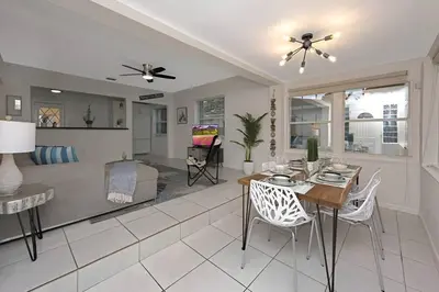 a dining room and living room with a table and chairs at The Palm House in Hollywood